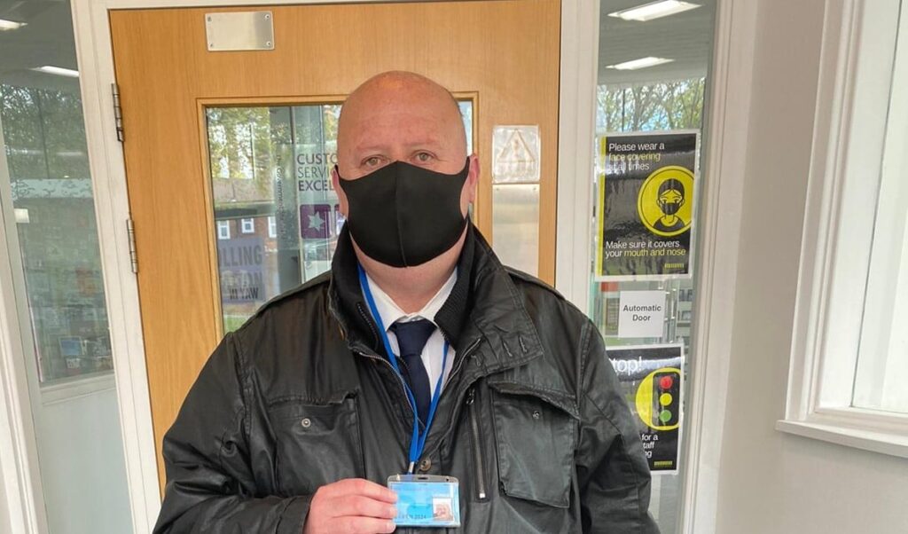 security guard wearing face mask and showing an id page for the security guard company gateshead page
