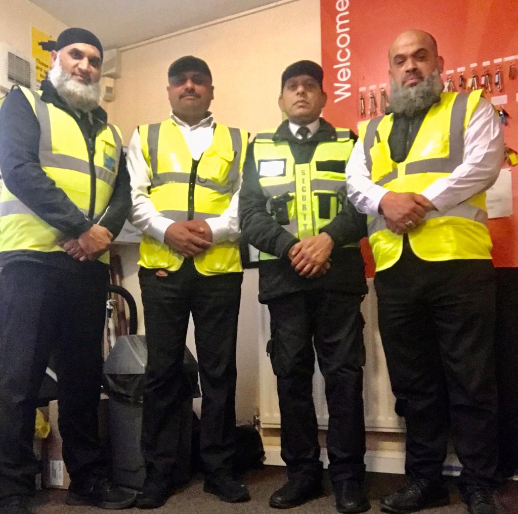 Four security guards standing together with hands grasping each other for the security company gateshead page